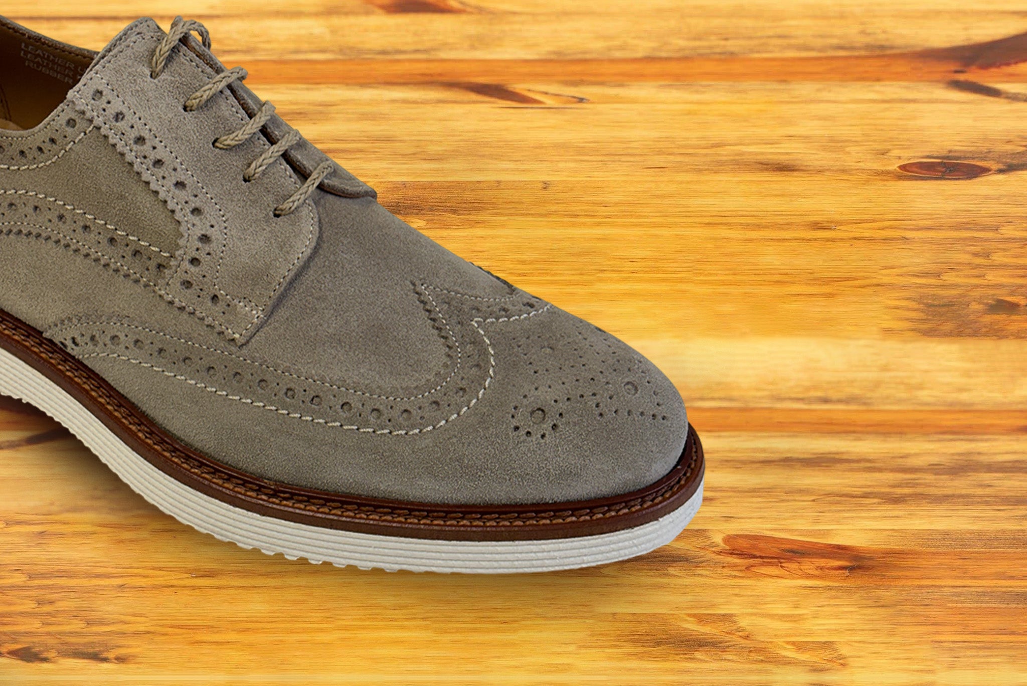 A Gray suede shoe  on a wooden surface