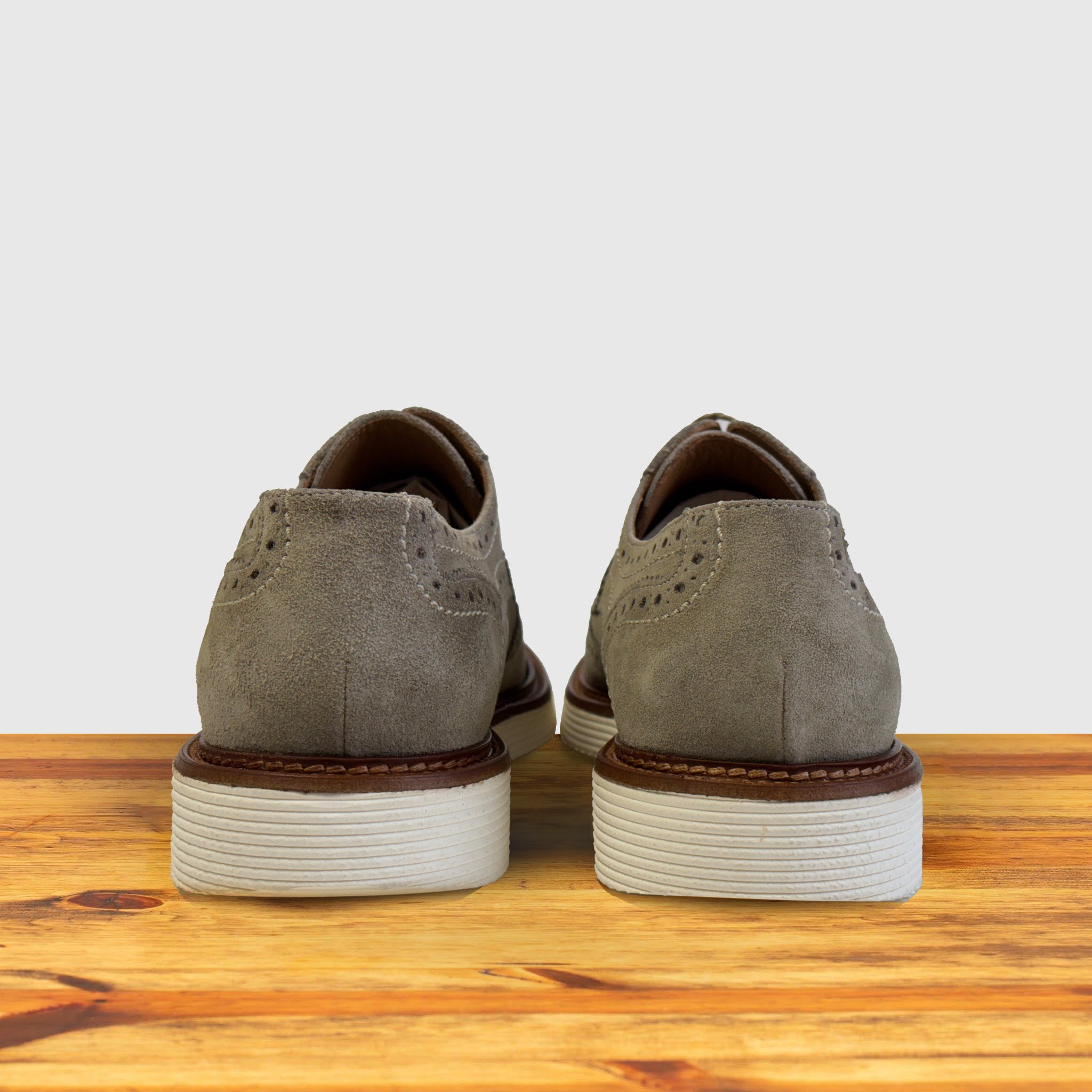 A pair of Gray suede shoe  on a wooden surface