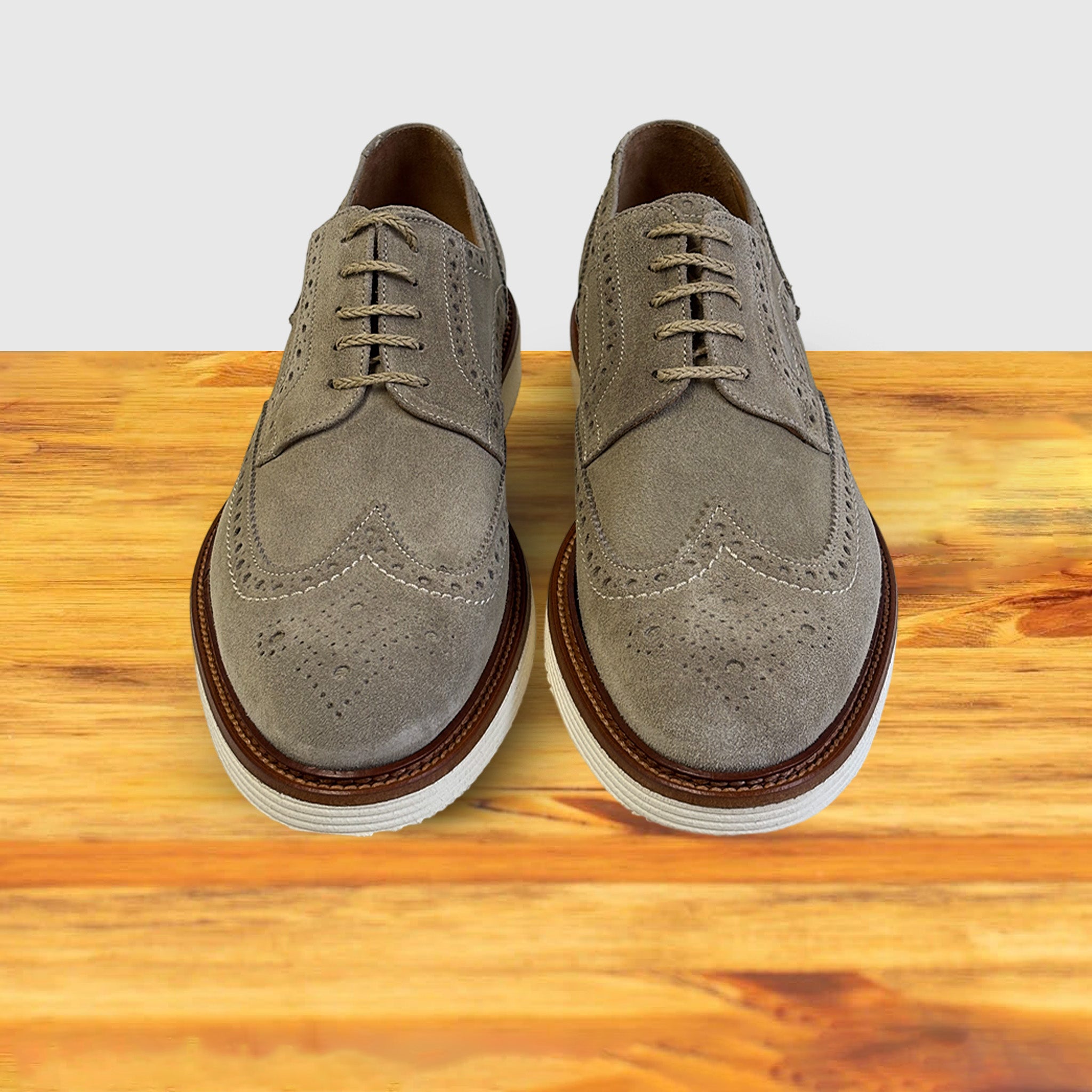 A pair of Gray suede shoe  on a wooden surface