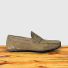 A Rope color suede penny loafer, displayed on a wooden surface.