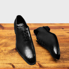 A Pair of Black leather dress shoe on a wooden surface with a light gray background