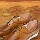 Brown leather shoe on a wooden surface