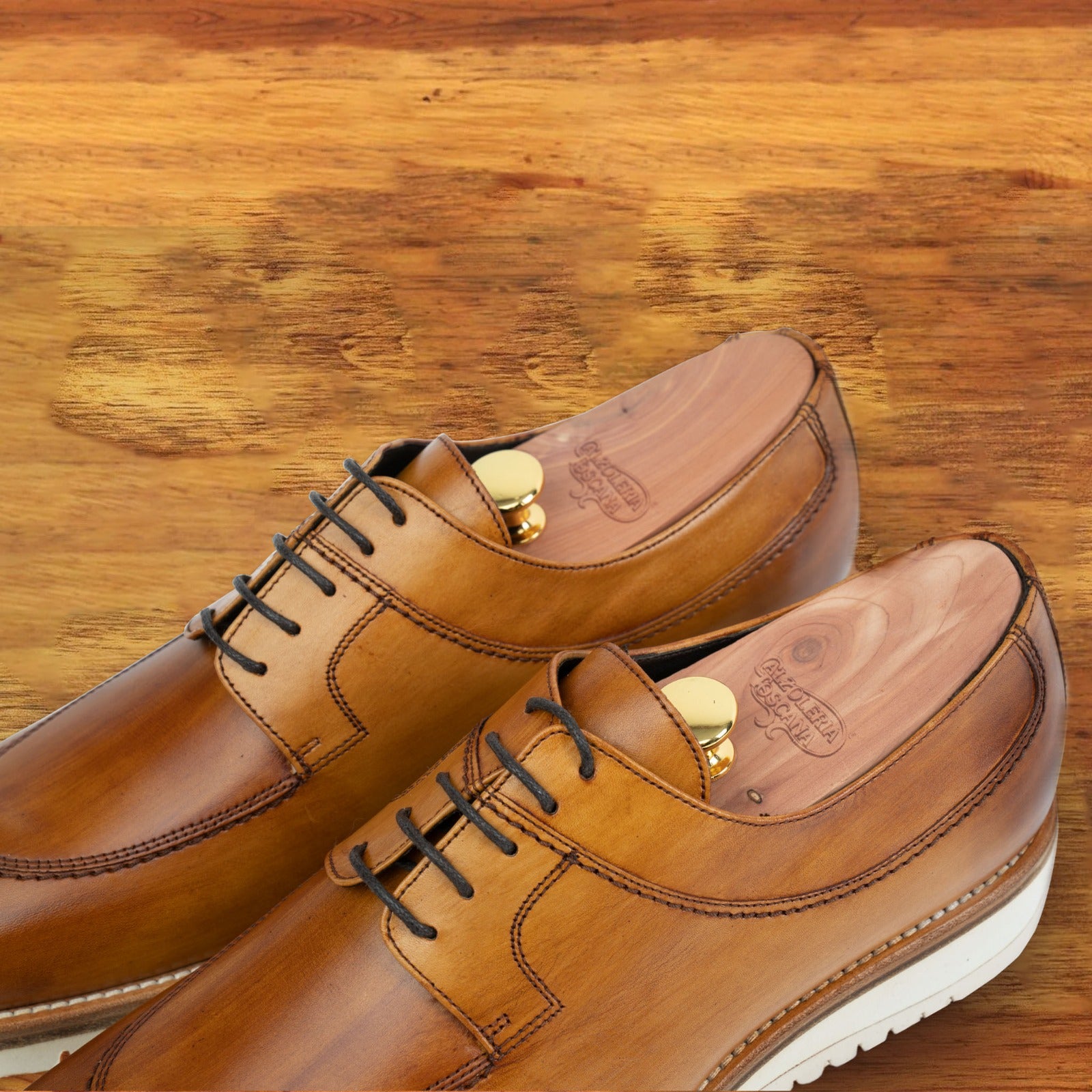 Brown leather shoe on a wooden surface