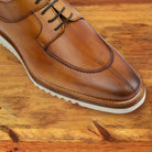 Brown leather shoe on a wooden surface