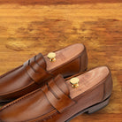 Dark Caramel leather loafer on a wooden surface
