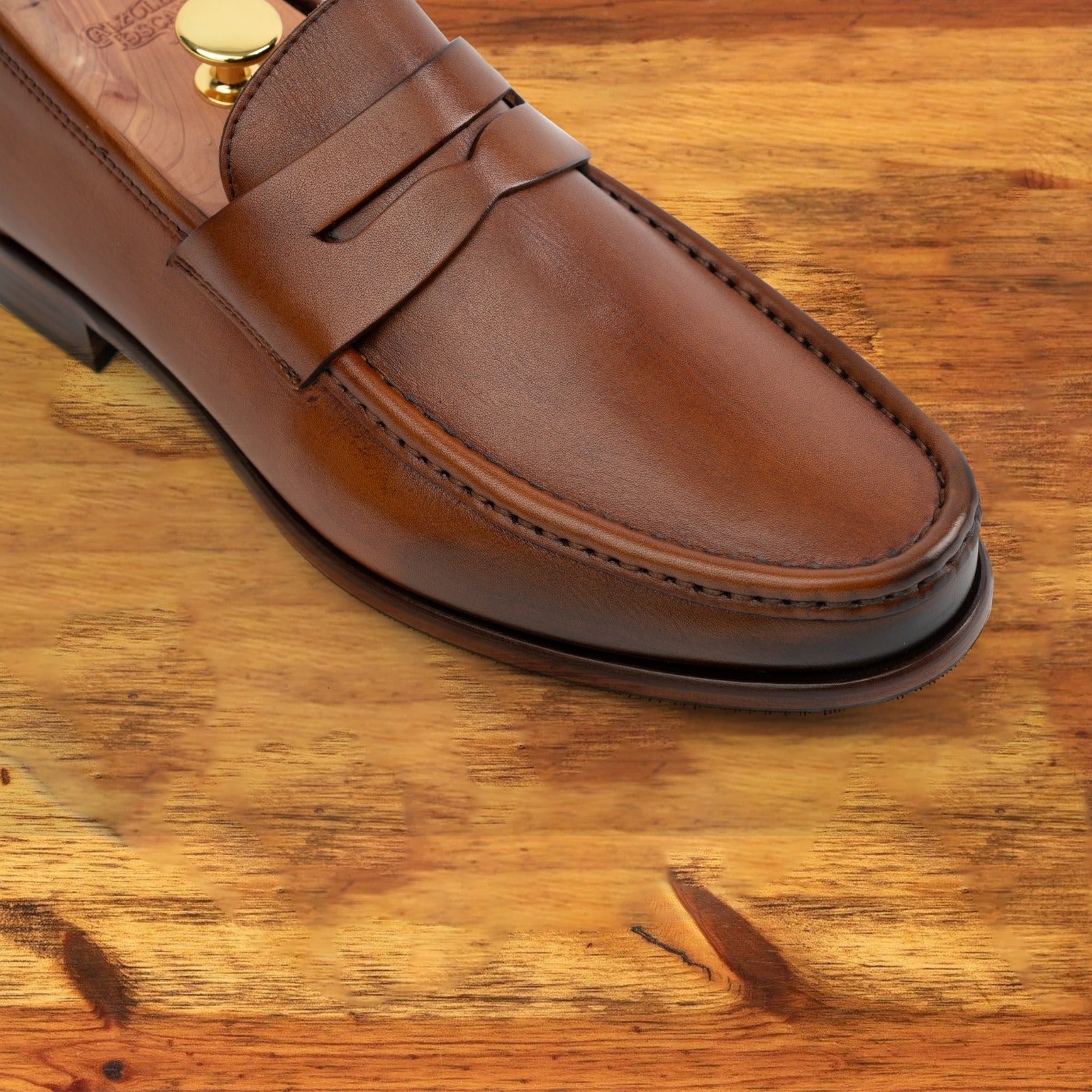 Dark Caramel leather loafer on a wooden surface