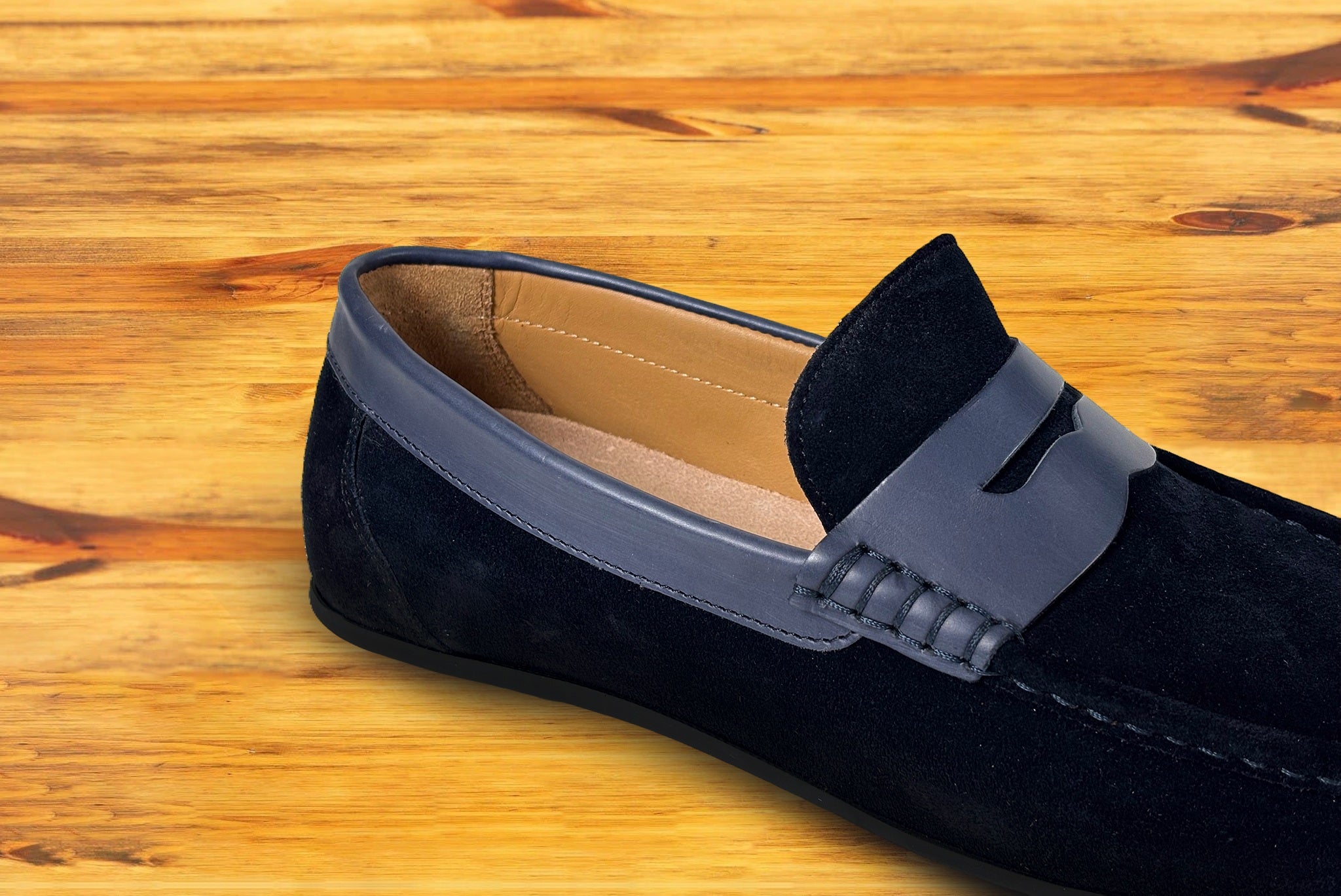 Blue loafer shoe with  strap on a wooden surface