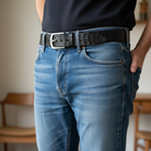 Person wearing blue jeans and a 4187 dress black belt with a blurred background