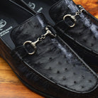 Close view of Black leather loafer on a wooden surface