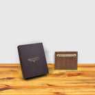 Blush crocodile-patterned cardholder with credit cards and box on a wooden surface and light gray background