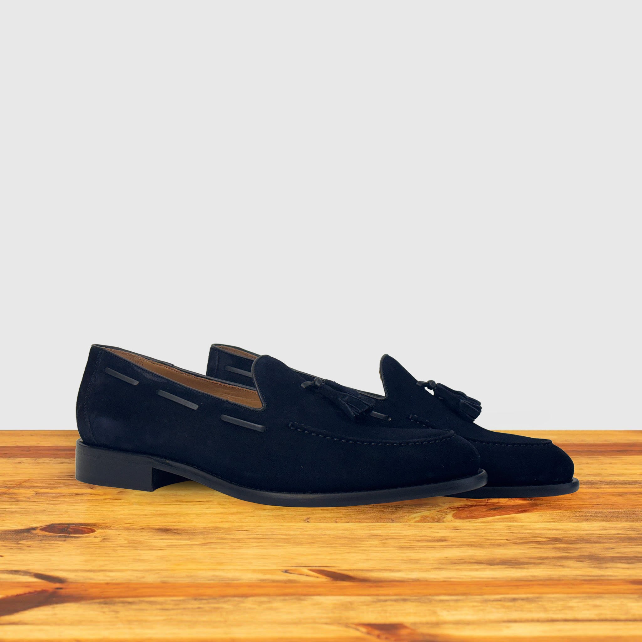 Pair of Navy blue loafer with a tassel on a wooden surface