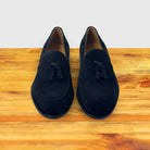  A Pair of Navy blue loafer with a tassel on a wooden surface