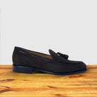 A Single Dusty Brown loafer placed on a wooden surface.