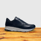 Blue sneaker with a white sole on a wooden surface
