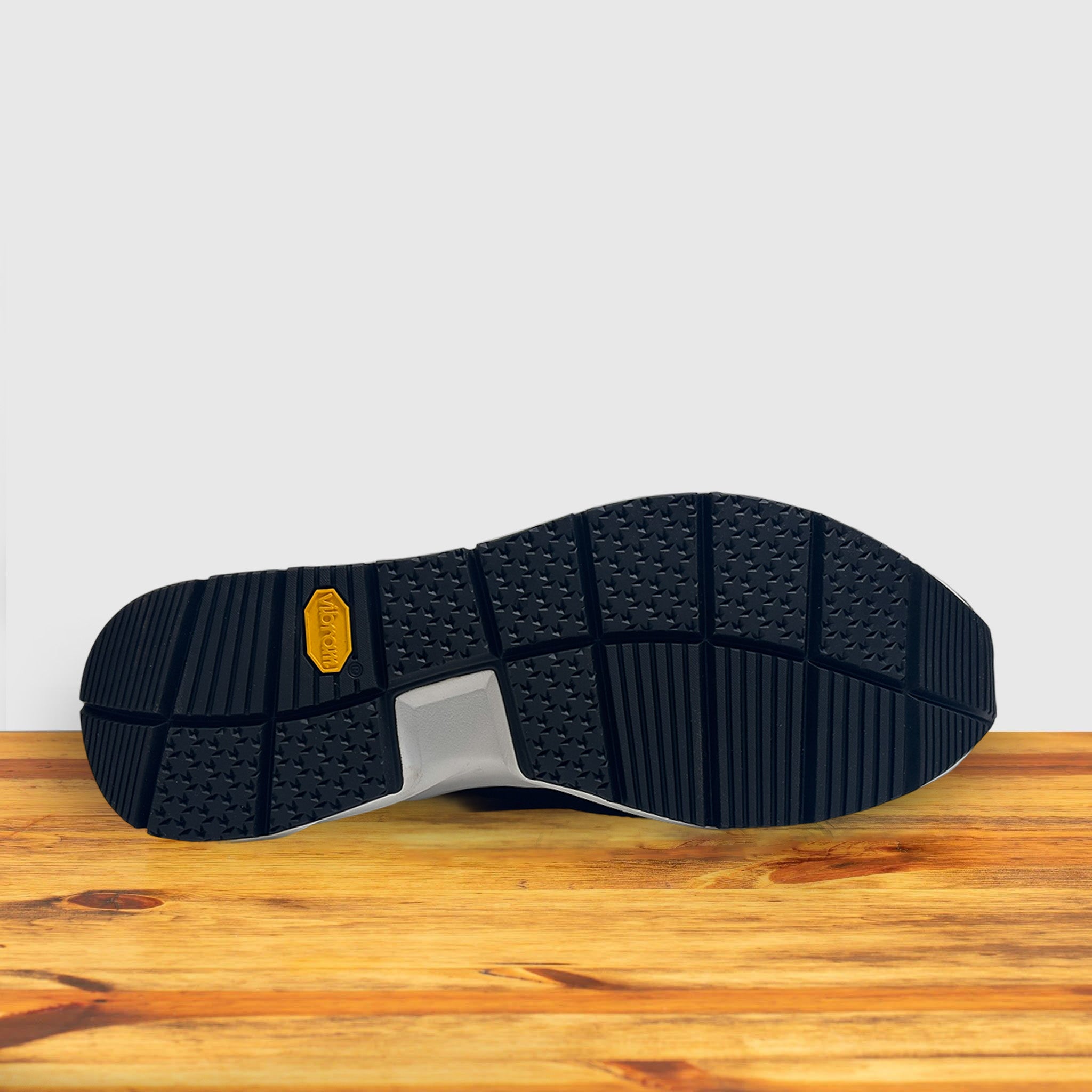 Outsole of Blue sneaker with a white sole on a wooden surface