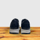 A pair of Blue sneaker with a white sole on a wooden surface