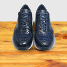 Pair of Blue sneaker with a white sole on a wooden surface