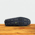 Outsole of a Navy Blue loafer shoe on a wooden surface