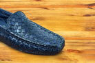 Navy Blue loafer shoe with woven pattern on a wooden surface