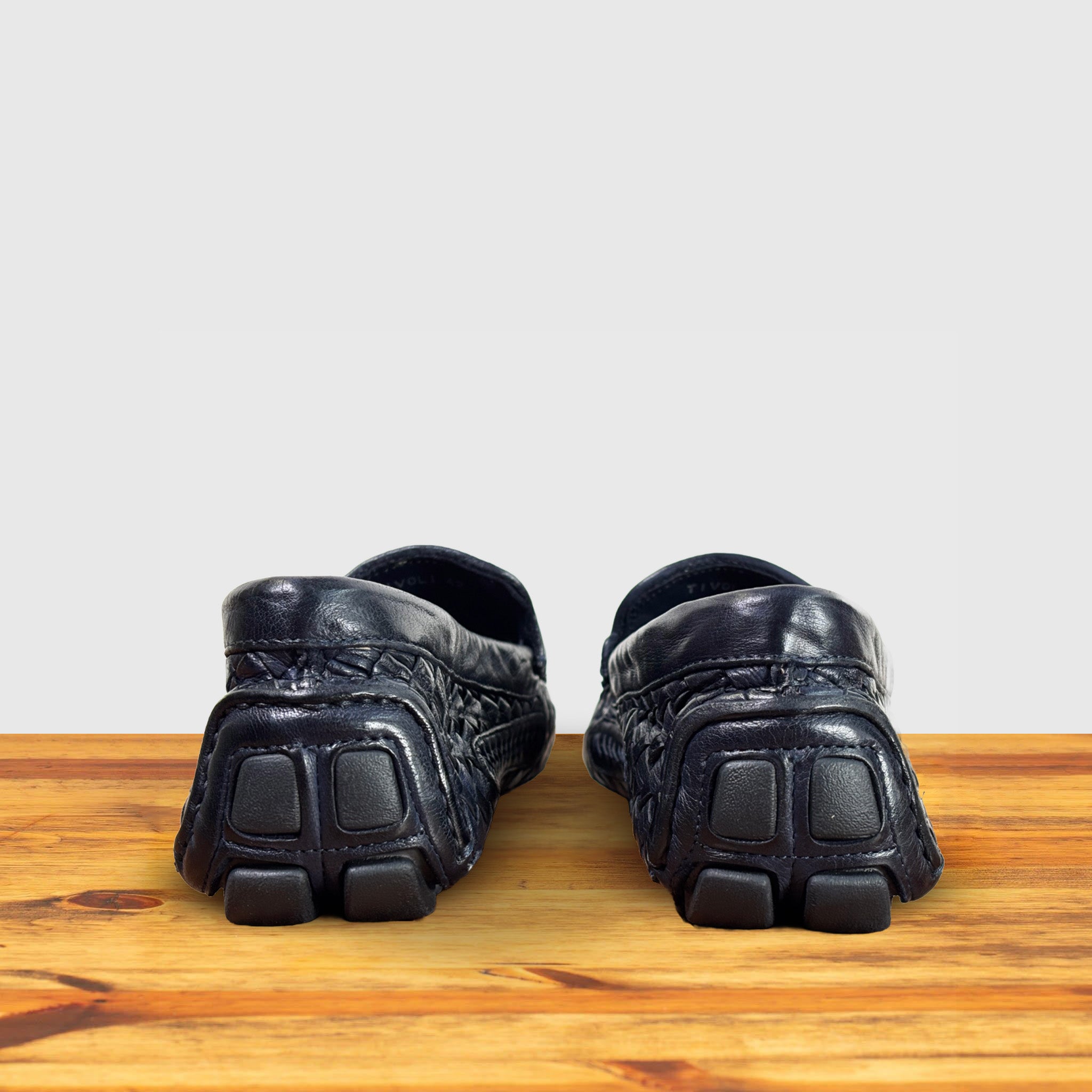 Navy Blue loafer shoe with woven pattern on a wooden surface