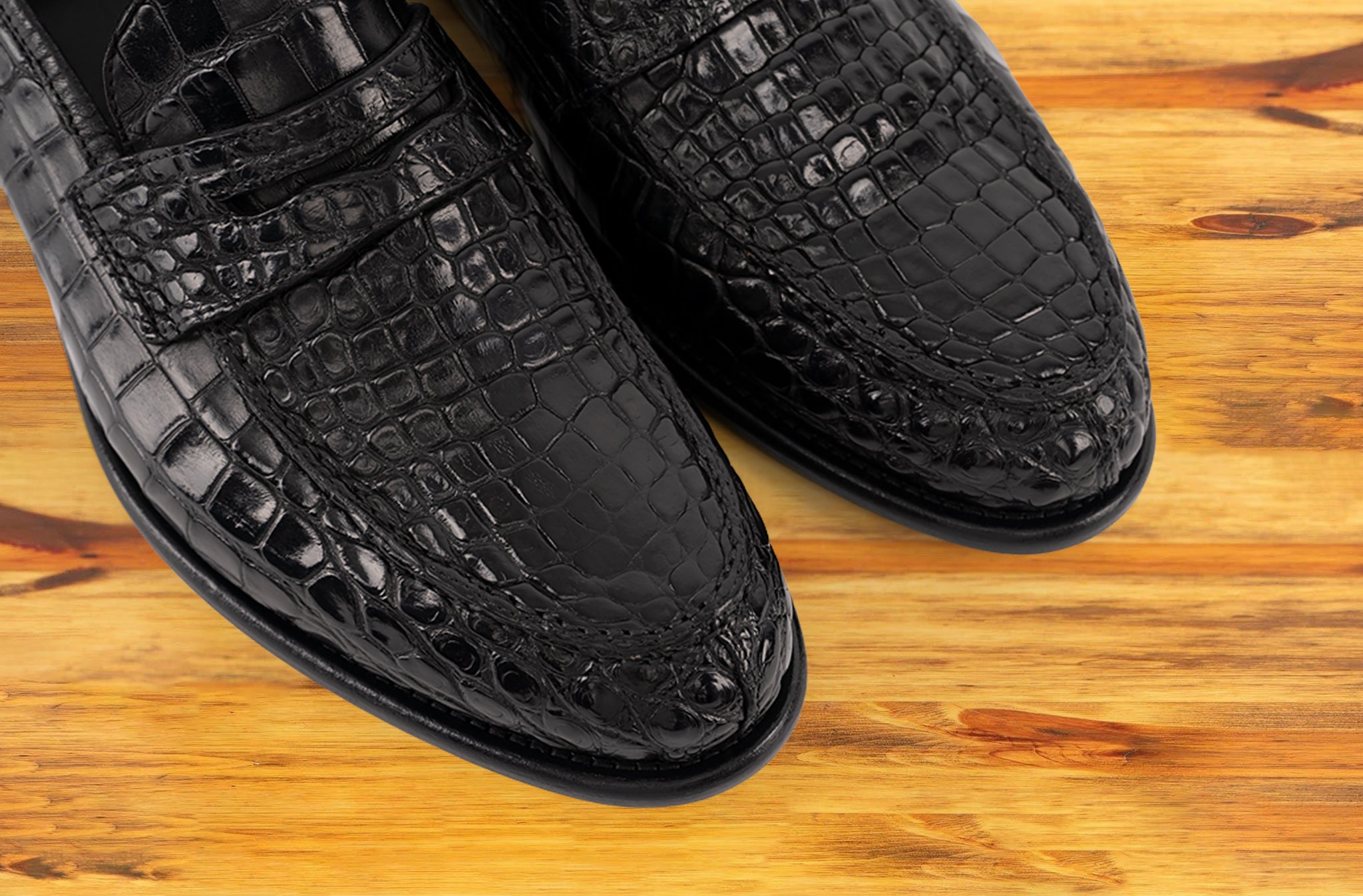 Black leather loafer on a wooden surface 