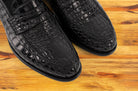 Black leather loafer on a wooden surface 