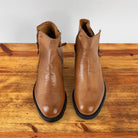 A Pair of of brick leather ankle boot with a double zipper design, placed on a wooden surface.
