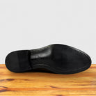 The smooth black leather outsole of a Dusty Brown dress shoe, shown from a bottom-up view