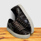 Dark Brown glossy sneakers with white soles on a wooden surface