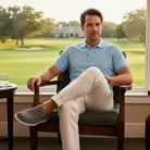 Man sitting in a chair by a window with a golf course view