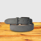 Gray belt with a silver buckle on a wooden surface