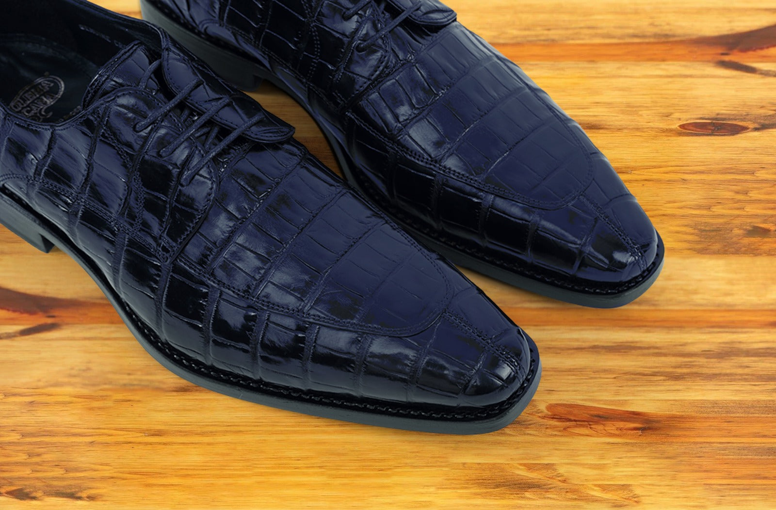 Blue crocodile shoe on a wooden surface