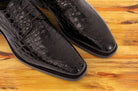 Brown crocodile shoe on a wooden surface