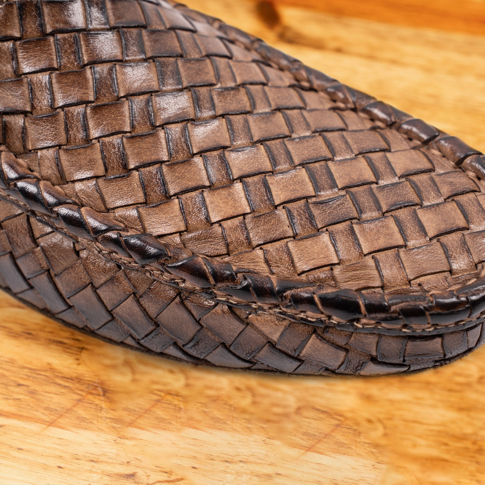 Close-up of Moor loafer shoe with woven pattern on a wooden surface
