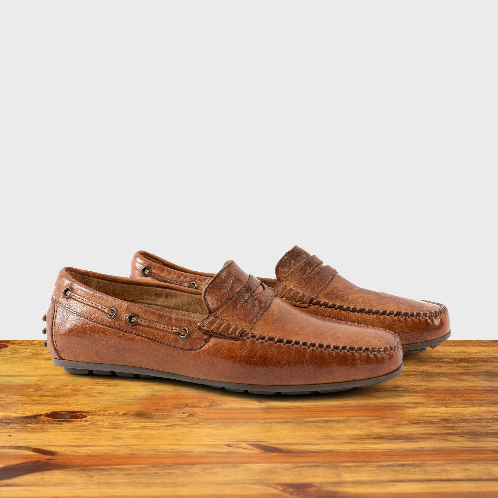 A Pair of Brick leather loafer on a wooden surface with a white background