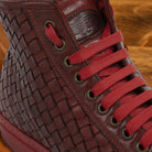 Cherry high-top sneaker with woven pattern on a wooden surface