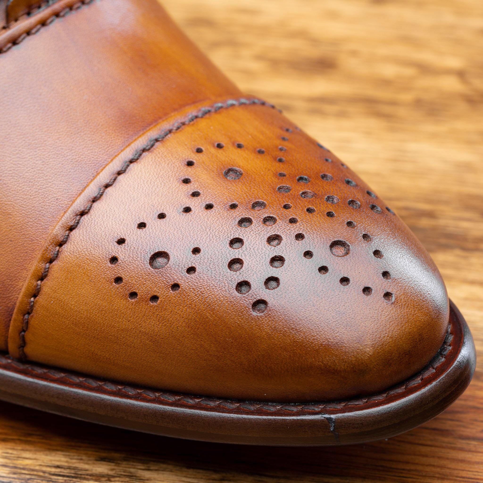 Close view of Dark Caramel leather dress shoe on a wooden surface
