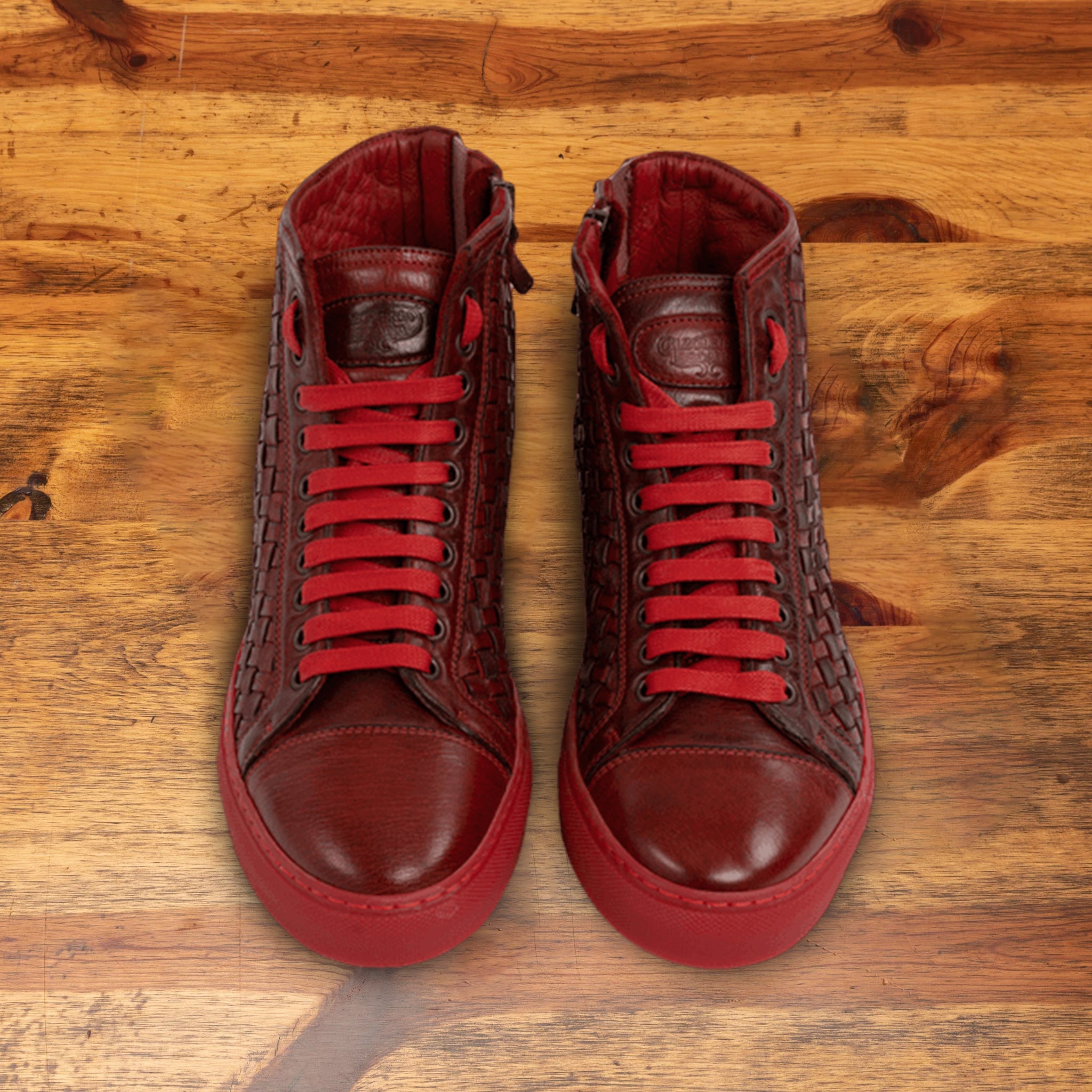 A Pair of Cherry high-top sneaker with woven pattern on a wooden surface