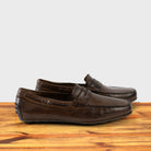 A Pair of Moor leather loafer on a wooden surface with a white background