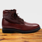 Cherry leather boots on a wooden surface