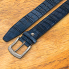 Blue textured belt with a silver buckle on a wooden surface