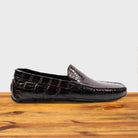 Dark Brown crocodile-patterned loafer on a wooden surface with a light gray background