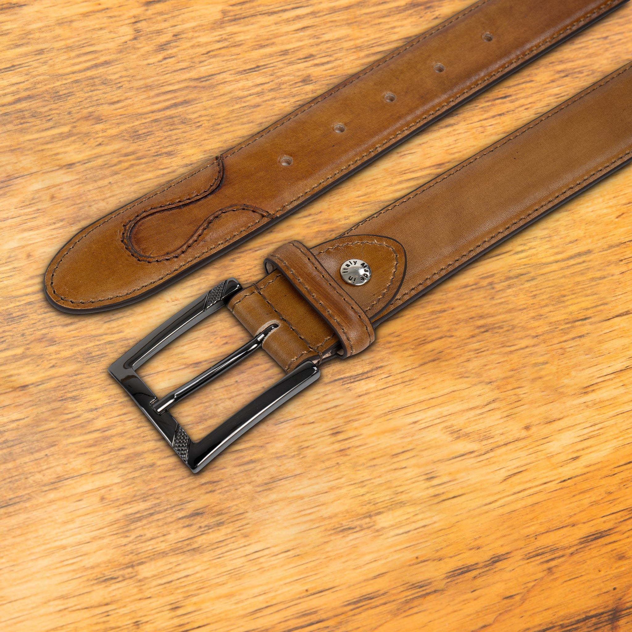Caramel leather belt on a wooden surface