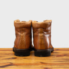 Back view of Brick leather boot on a wooden surface with a light gray background
