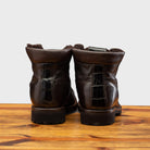 Back view of Dark  Brown leather boot on a wooden surface with a light gray background