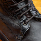 Close-up of Dark Brown leather boot on a wooden surface