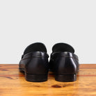 back view of Blue loafer shoe on a wooden surface with a light gray background