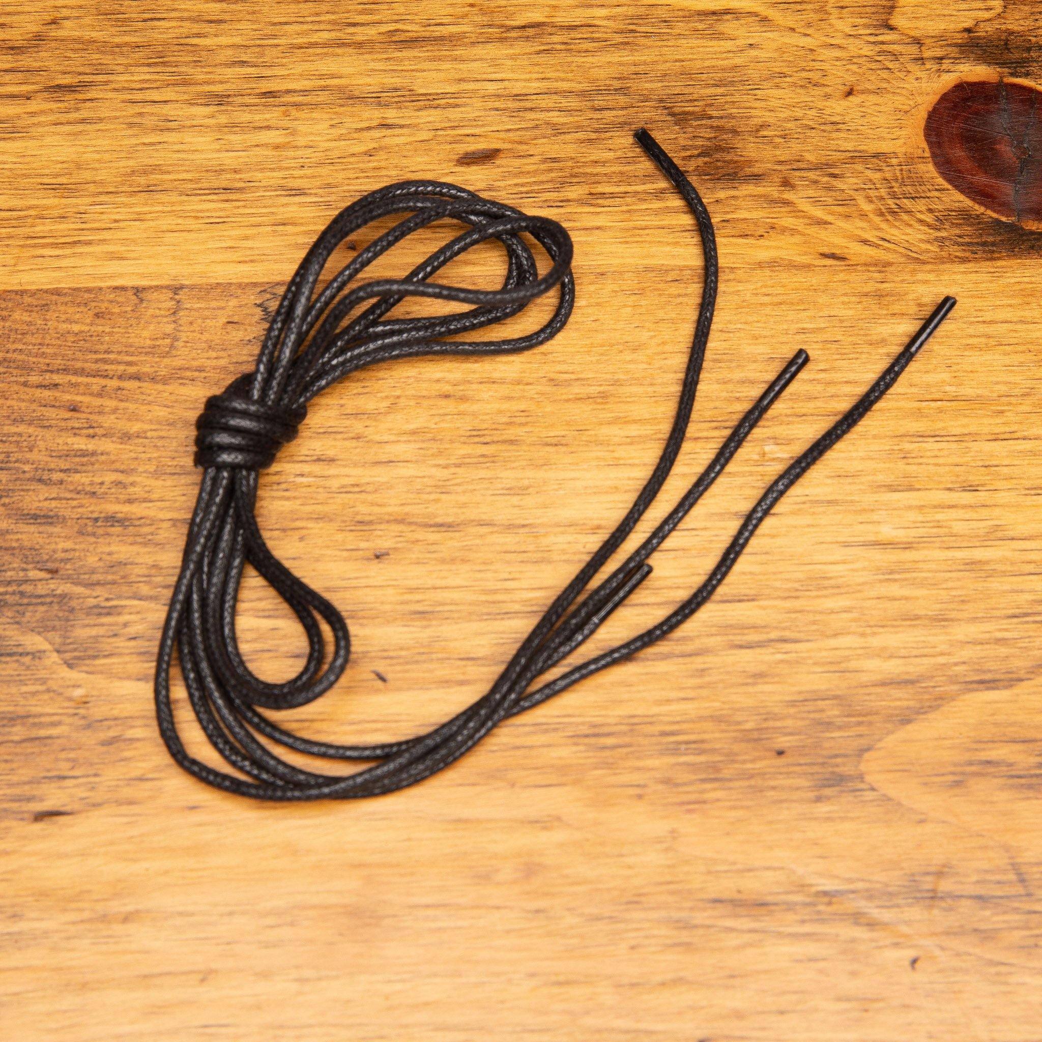 Black shoelaces on a wooden surface