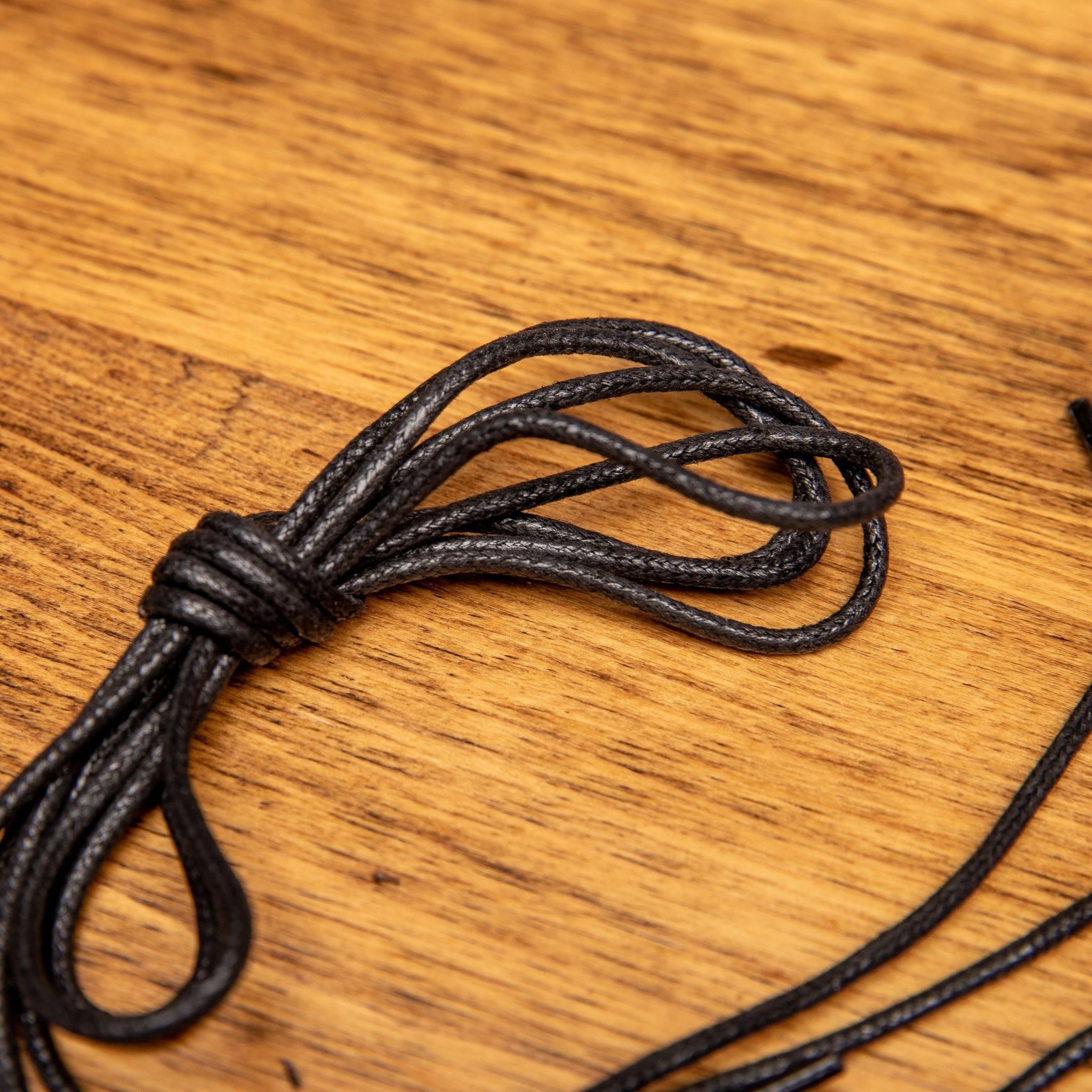 Black shoelaces on a wooden surface