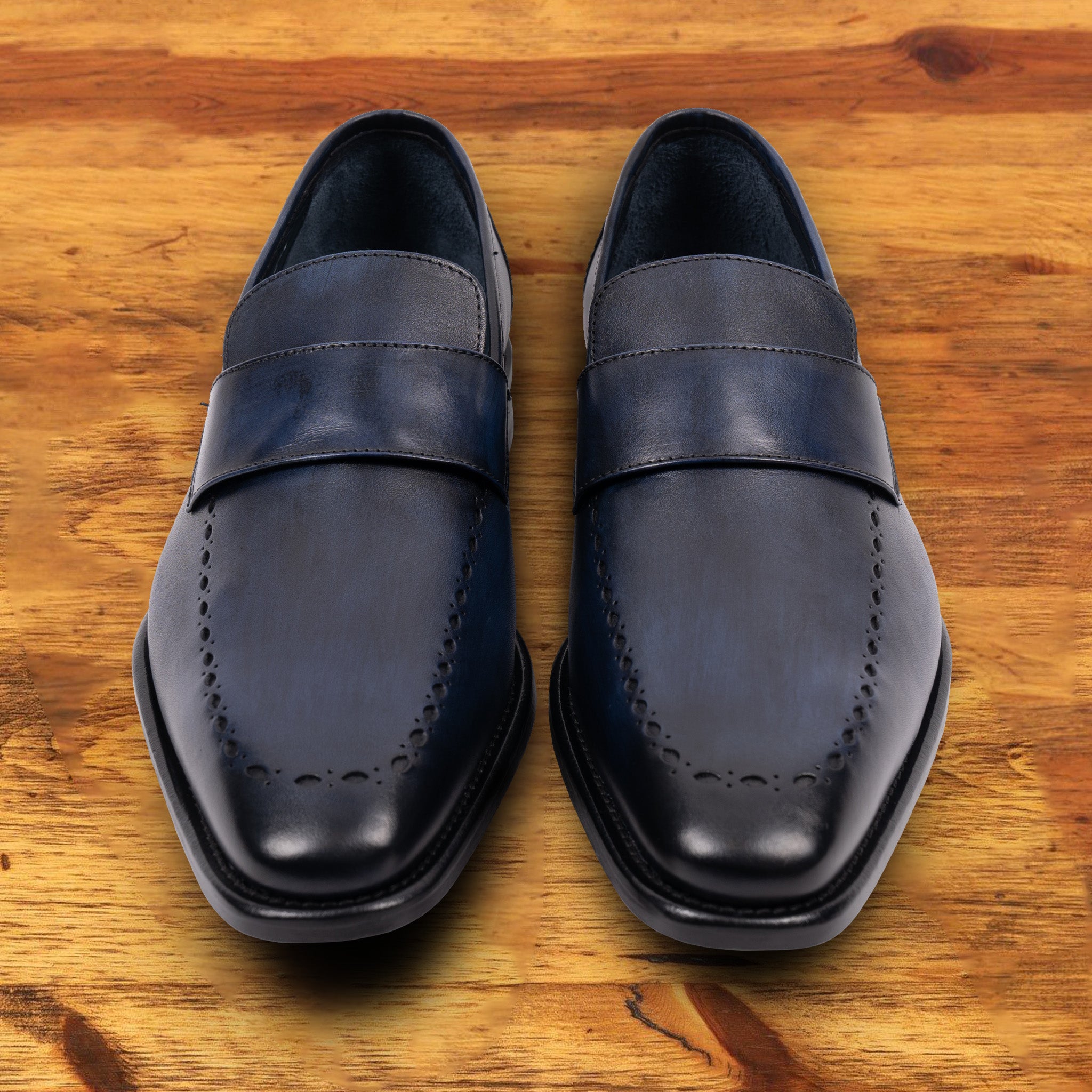 Pair of Blue leather loafer on a wooden surface